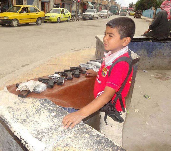 سوريا: طفل يبيع أسلحة نارية في منطقة تحت سيطرة العصابات المسلحة+صورة