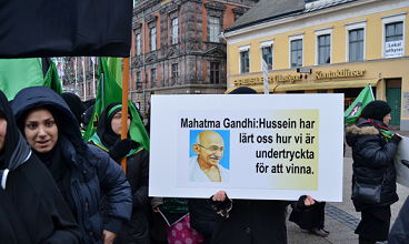 مسيرة الاربعينية في مدينة مالمو السويدية تتواصل مع كربلاء وتوزع الورود على المارة تعريفا بالحسين (مصور)