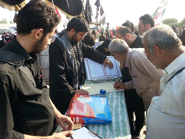 بالصور: كتابة القران الكريم بأيادي زائري الاربعين