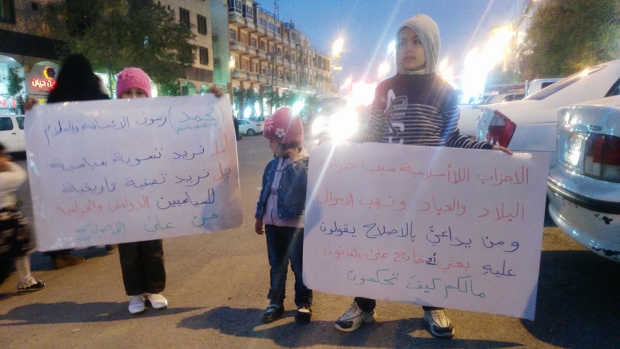 بالصور:عائلة تتكون من اب وثلاث اطفال يحتجون ضد الفساد وسط كربلاء