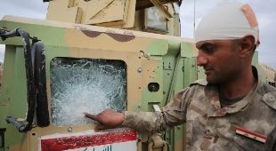 بالصور.. جندي عراقي يعالج جرحه بمواصلة القتال قرب تكريت