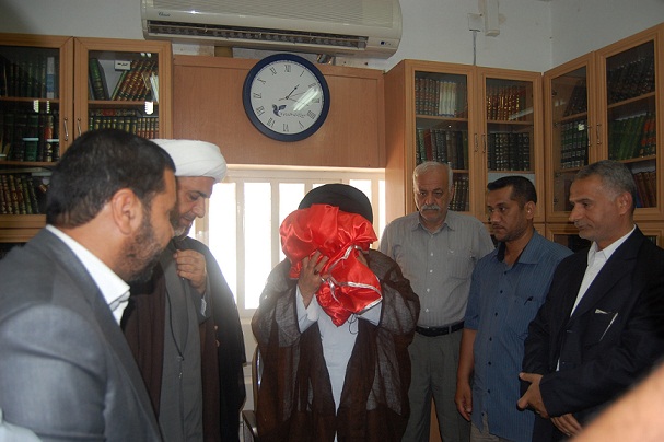 ممثل المرشد الايراني يقبل راية الامام الحسين عليه السلام (مصور)