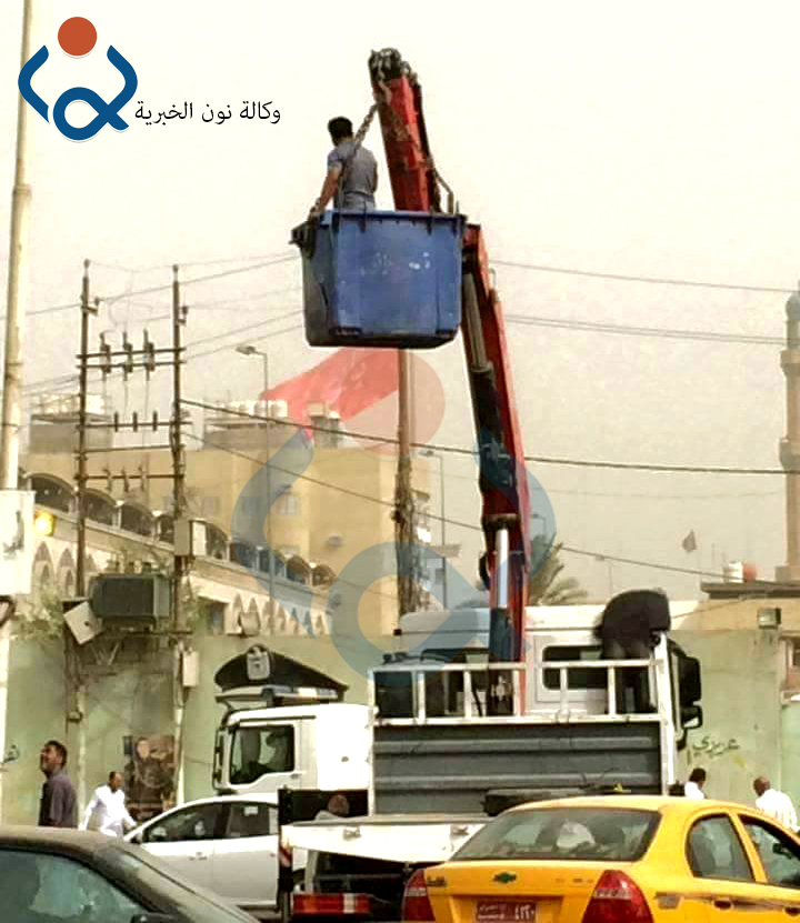 بالصور: عامل كهرباء يستخدم حاوية للنفايات لتصليح اعمدة الكهرباء وسط كربلاء