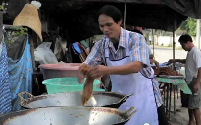طباخ تايلندي يقلي الدجاج بيده ولا يحترق