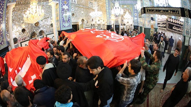 بالصور.. العتبة الحسينية ترفع رايتي الإمام الحسين وأخيه العباس على قبة السيدة زينب في دمشق