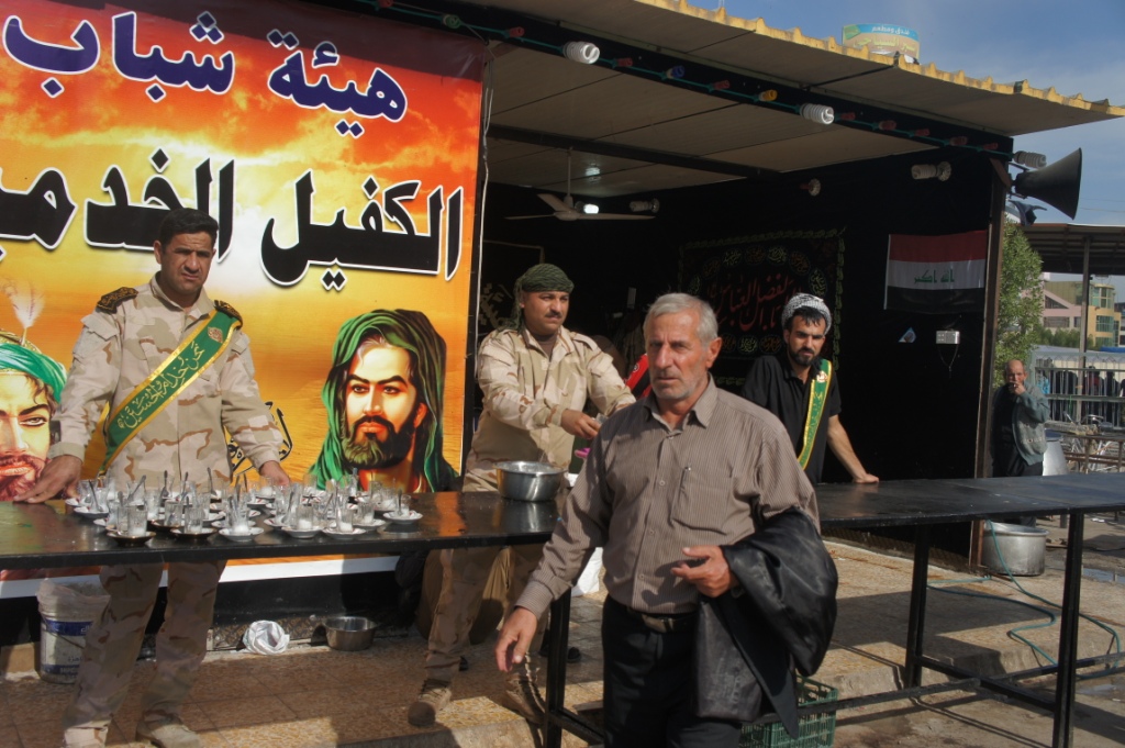 بالصور:القوات الامنية في كربلاء يد تقاتل ويد تطعم الزائرين