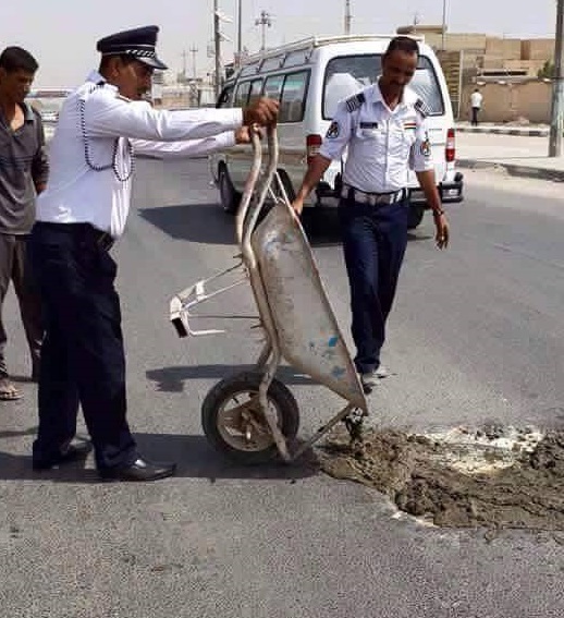 في بغداد رجال المرور يصلحون الشوارع (مصور)