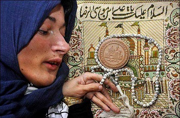 سيدة معاقة تنجز اعمال يدوية باسم الامام علي بن موسى الرضا (مصور)