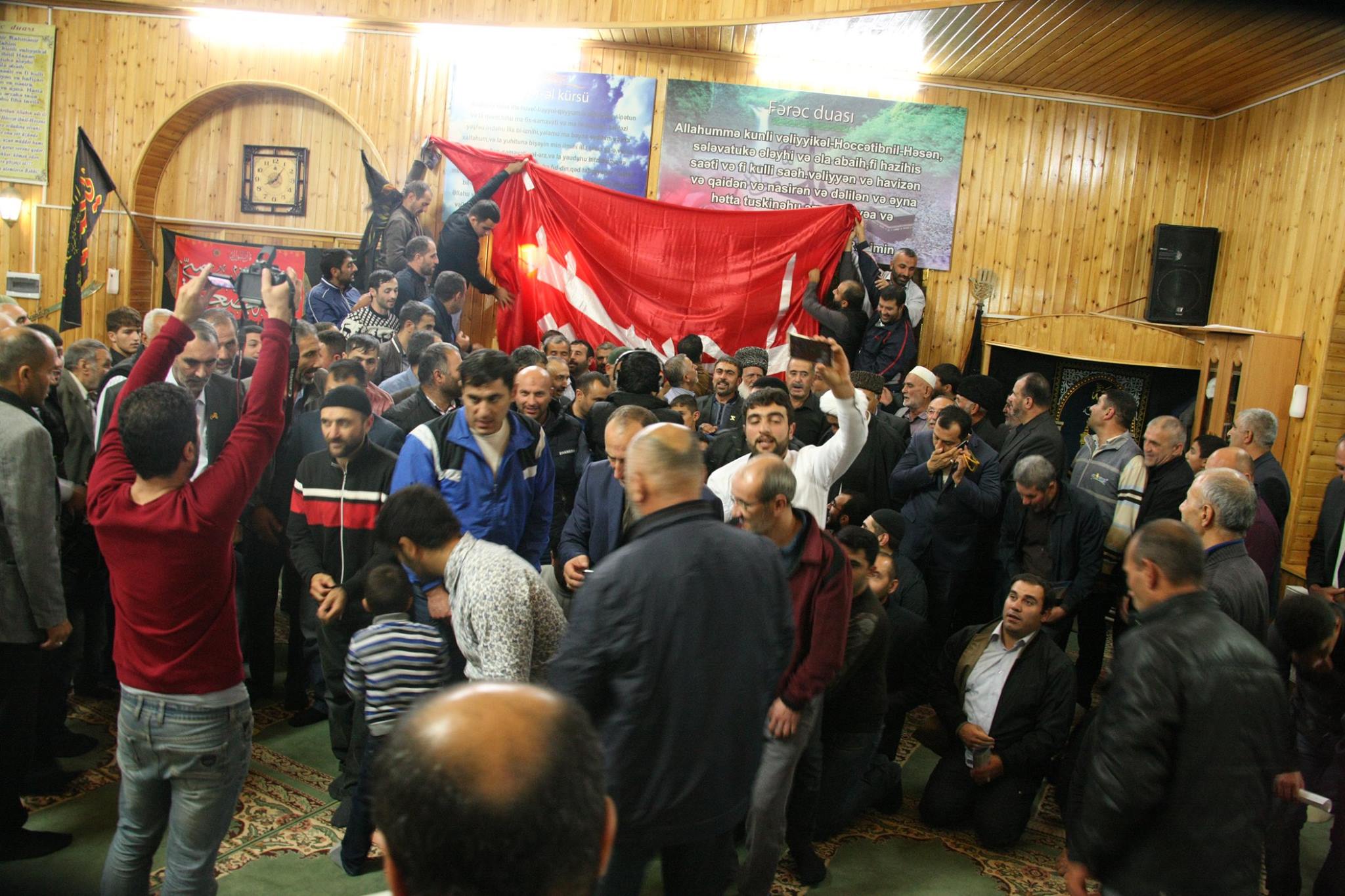 بالصور:الاذربيجانيون يتبركون براية الامام الحسين واطفالهم يشاركون بمعارض فنية حسينية