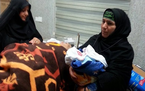 سيدة ايرانية تنجب بكربلاء عن طريق مستشفى متنقل وتستمر بالسير الى المرقد الحسيني المطهر مع طفلتها (مصور)