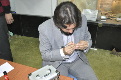 خطاط ايراني يخط على حباب الارز وشعرة الراس يهدي اعماله لمتحف الامام الحسين في كربلاء