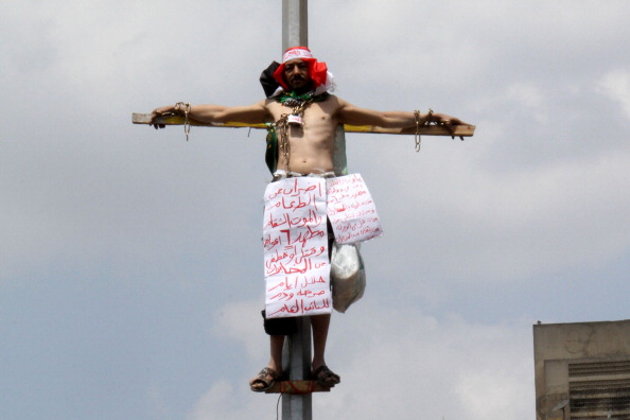 مصري يصلب نفسه على عمود إنارة بميدان التحرير وسط القاهره(مصور)