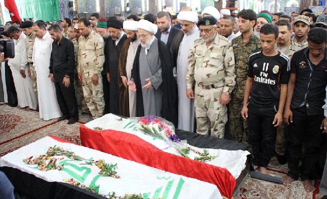 بالصور:ممثل المرجع السيستاني يصلي على جثماني شهيدين قضيا قرب سامراء اثناء قتالهم ضد داعش