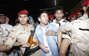 احد عناصر الأمن السعودي يضع فوهة بندقيته في حلق (ميسي) اثناء وصوله لمطار الملك خالد+صورة