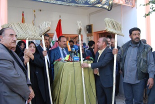 اعضاء القائمة العراقية في كربلاء يرفعون مكانس يدوية الصنع كشعار لبرنامجهم الانتخابي (مصور)