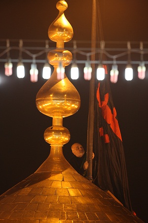 استبدال رايتي مرقدي الامام الحسين واخيه العباس من الحمراء الى السوداء وسط حضور جماهيري ايذانا ببدء شهر محرم (مصور)