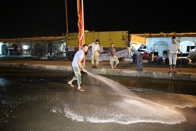 بالصور:متطوعو العتبة الحسينية المقدسة يغسلون شوارع سامراء