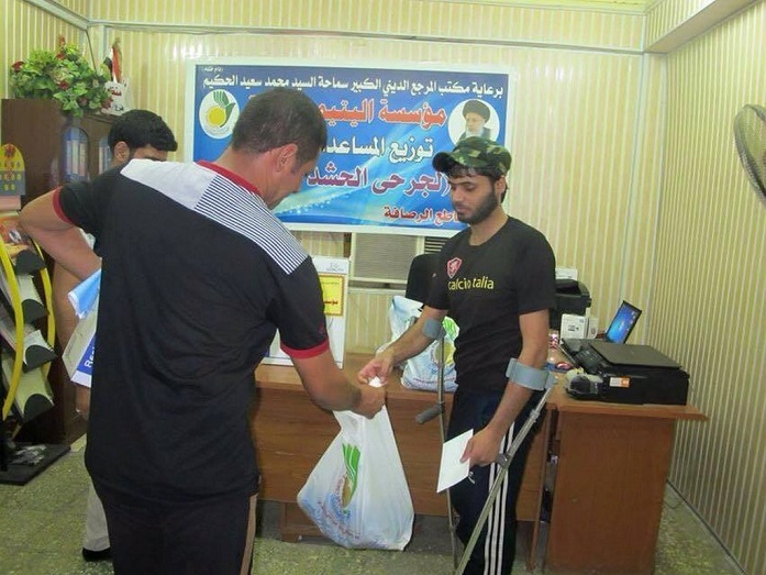 مؤسسة خيرية تابعة للمرجع الحكيم توزع سلع منزلية ومساعدات على جرحى الحشد والمتعففين في بغداد