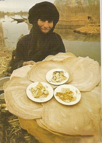 صورة ارشيفية لأمراة ميسانية وهي تبيع خبز السياح (خبز اهل العمارة) في خمسينات القرن الماضي