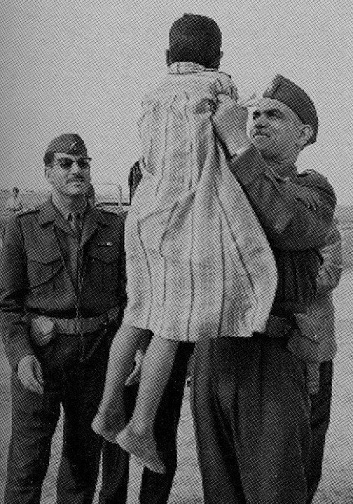 صورة ارشفية لعبد الكريم قاسم وهو يحمل طفل عراقي