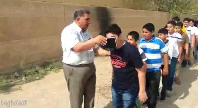 مدير مدرسة في كربلاء يتابع طلبته اثناء الامتحانات الوزارية ويمرر المصحف الكريم من فوق رؤوسهم قبل الامتحان(مصور)