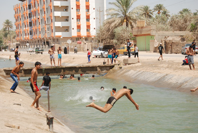 كربلاء :مراهقون يقضون العيد سباحة في الانهر الفرعية واهالي المنطقة  يشكون تواجدهم بالمناطق السكنية (مصور)