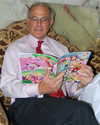 صورة حديثة جدا للسفير البريطاني ببغداد وهو يطالع مجلة خاصة بالاطفال اثناء زيارته لكربلاء