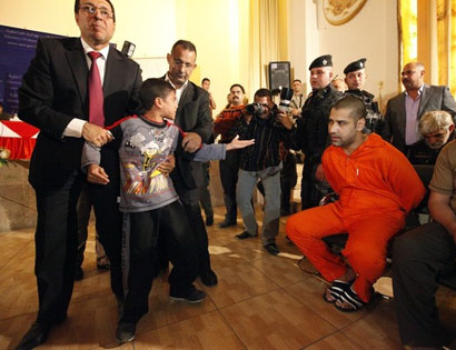 صور مثيرة/ صبي يتشاجر مع قاتل والده خلال مؤتمر صحافي عقد لإعترافات خلايا البعث