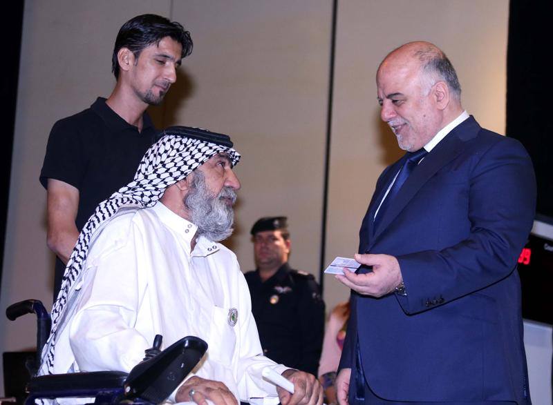 بالصور: العبادي يُسلّم والد الشهيد مصطفى العذاري اول بطاقة وطنية موحدة