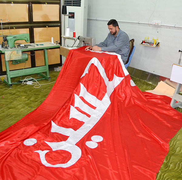 شاهد بالصور :كيف تتم خياطة وتطريز رايات قبة الإمام الحسين (عليه السلام) في كربلاء المقدسة