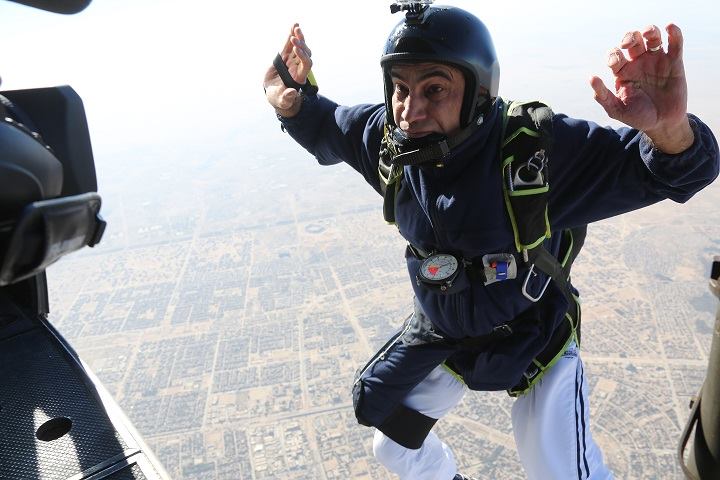 صورة المظلي العراقي شاكر الساعدي لحظة انطلاقه من الطائرة وهو يحمل بين ثناياه راية ياحسين باتجاه بين الحرمين اثناء زيارة الاربعين في كربلاء