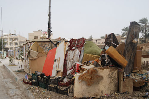 امراة من ابوين عراقيين تتخذ صفائح حديدية وعلب كارتونية دارا لها في مركز مدينة كربلاء(مصور)