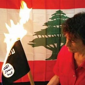 شاعرة ورسامة لبنانية تحرق علم داعش انتقاما لمجازر هذه العصابة