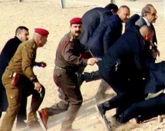 صورة لنائب رئيس الوزراء صالح المطلك وهو يفر مع حمايته بعد رميه بالحجارة بالانبار