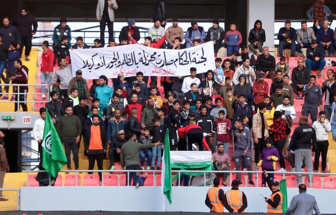 بالصور:ظاهرة تحدث لاول مرة على  ملعب كربلاء: جماهير العميد ترفع صور حكام ظلموا ناديهم