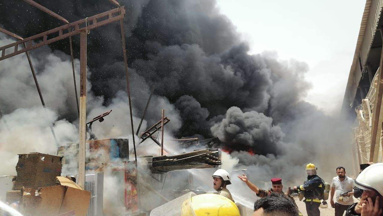 الدفاع المدني ينقذ بناية ويخمد حريق مجمع تجاري في النجف (صور)