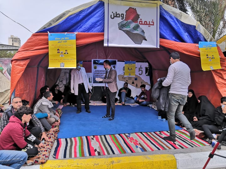 بالصور: ندوة حوارية يقيمها محتجون مع دائرة صحة كربلاء بخصوص فايروس كورونا في ساحة الاحرار